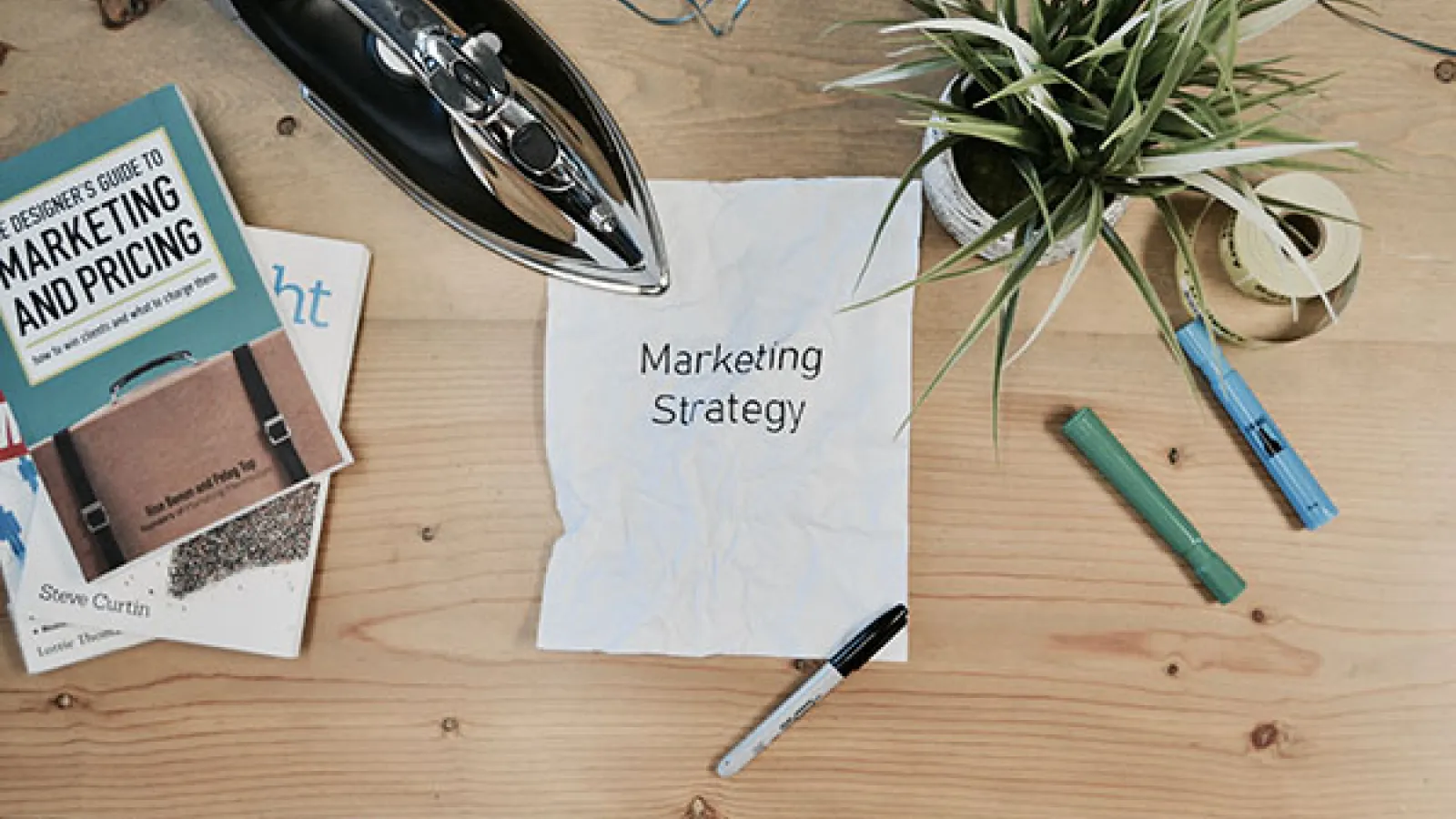 Paper stating "Marketing Strategy" on a messy desk
